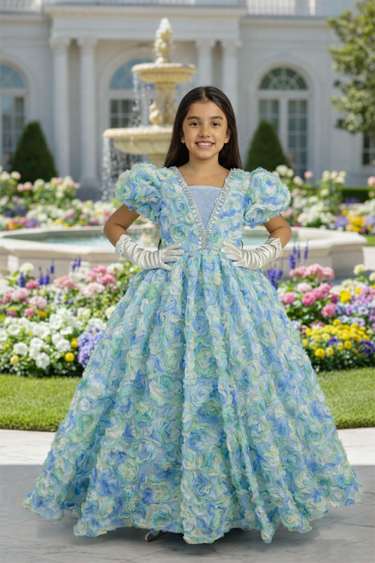 Young girl in a floral dress standing in front of a fountain and garden.