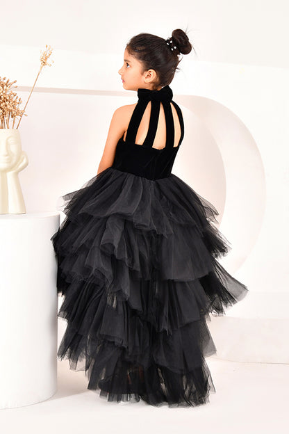 Young girl wearing a black high low dress from nibblekins with white background