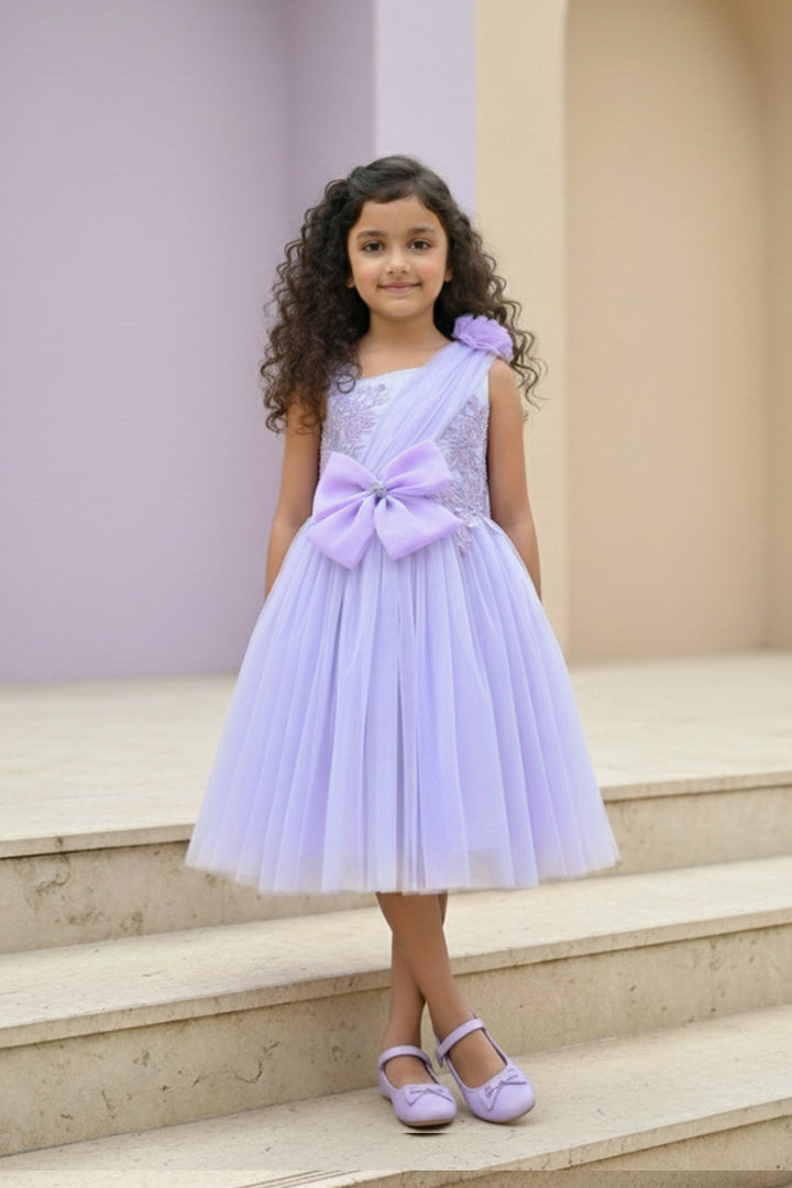 A young girl in a lavender dress from Nibblekins with a large bow is standing on the steps.
