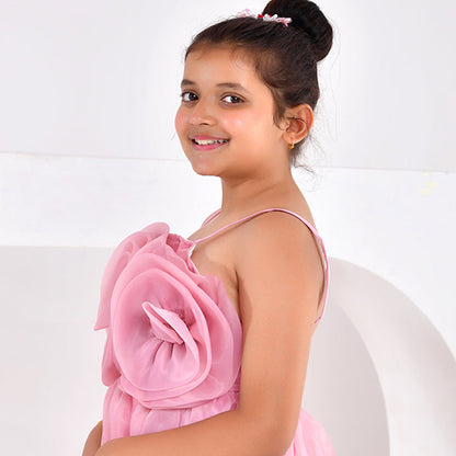 Young girl wearing a pink dress with floral details on a white background