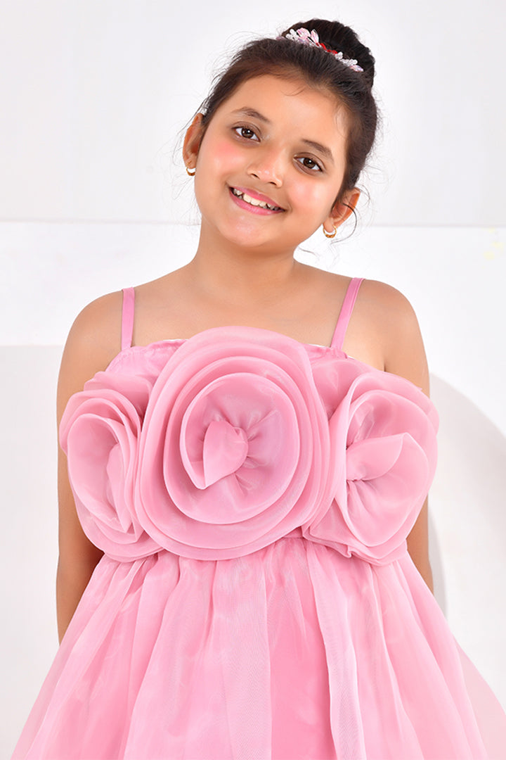 Young girl wearing a pink dress with a large floral design on a white background
