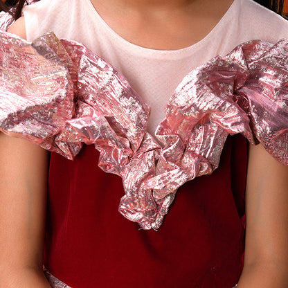 Close-up of a person wearing a red top with pink ruffled sleeves.