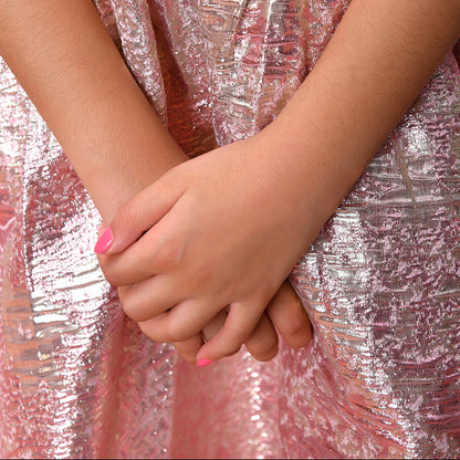 Close-up of hands clasped together with a person wearing a red top and pink metallic skirt.