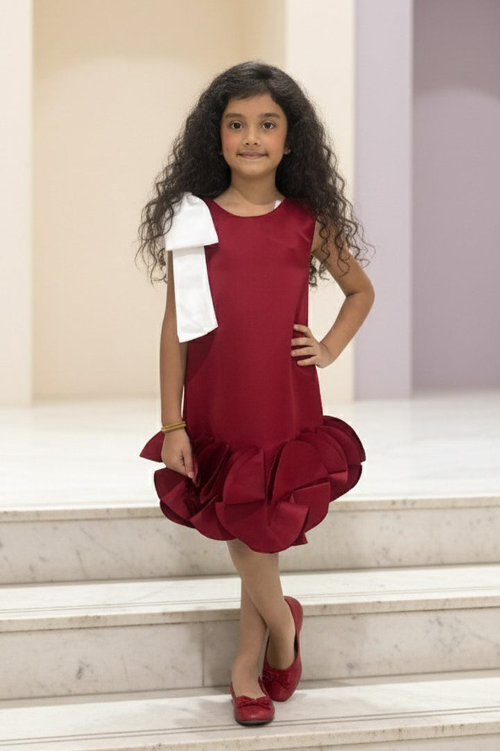 Young girl in a red dress from Nibblekins with ruffles standing on marble steps.