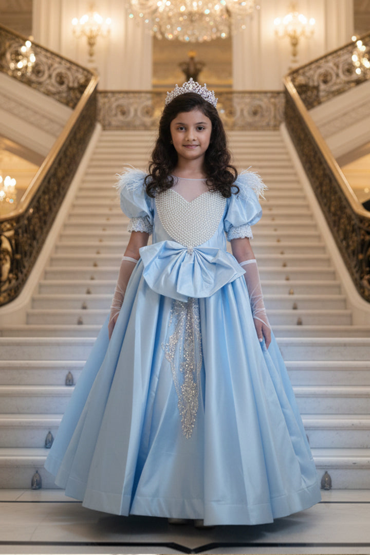 A young girl in a Cinderella gown from Nibblekins with a tiara is standing on a grand staircase