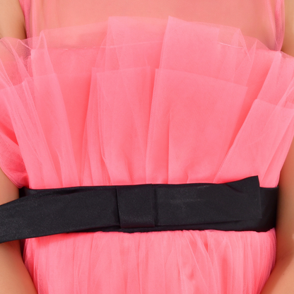 A close-up of a bright pink tulle dress with a wide black satin bow tied around the waist.