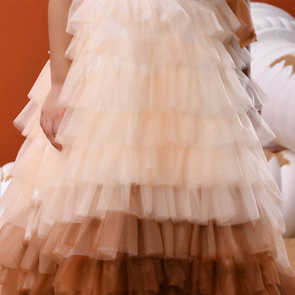 Layered ruffled skirt with a gradient from beige to brown on an orange background