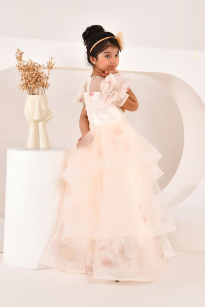 Young girl in a ivory dress from nibblekins standing in a minimalistic setting with a vase of dried flowers.