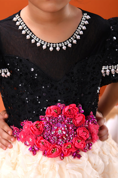 Black outfit with pink floral embellishments and silver jewelry on an orange background