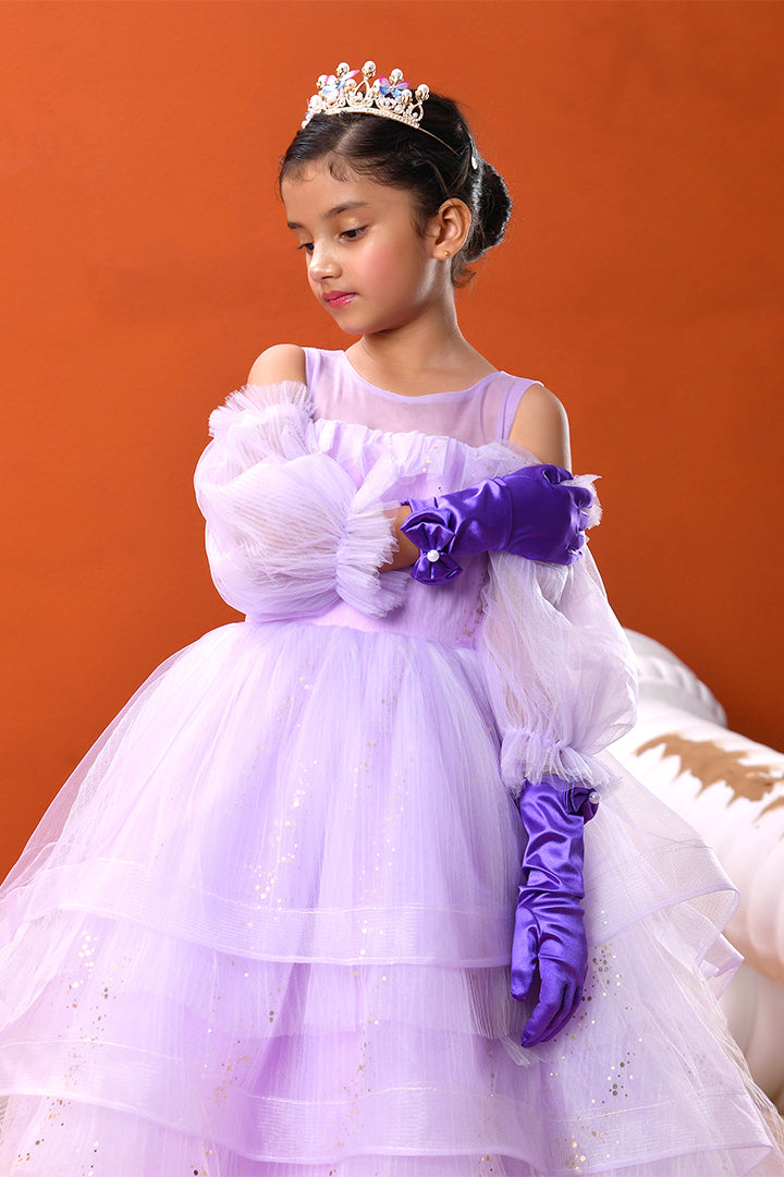 Young girl in a purple dress with a tiara against an orange background
