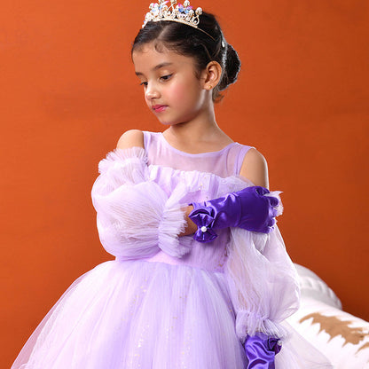 Young girl in a purple dress with a tiara against an orange background
