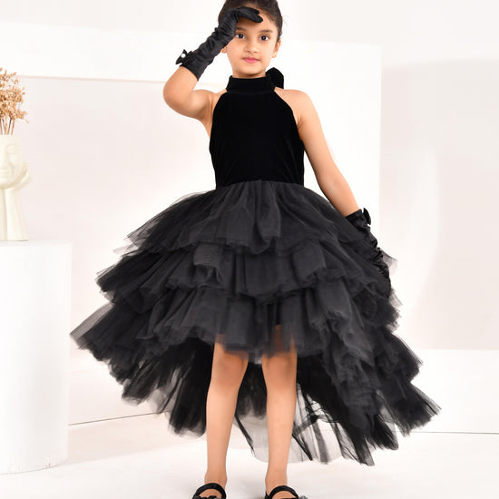 a young girl wearing black high low dress from nibblekins with white background 