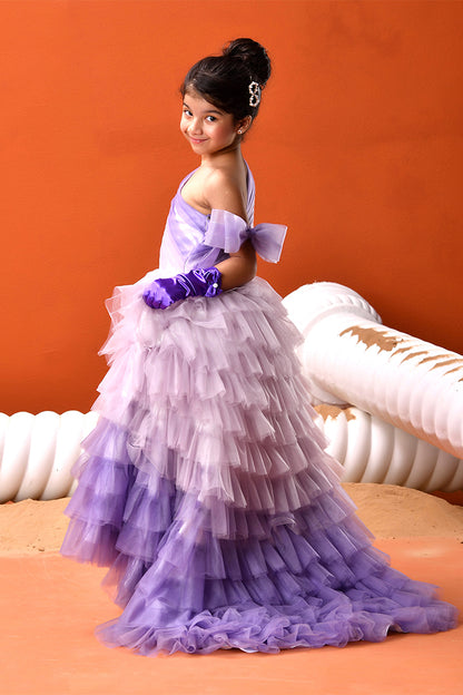 Young girl in a purple dress with ruffles against an orange background