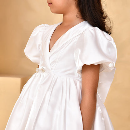 Young girl in a white dress with a beige background