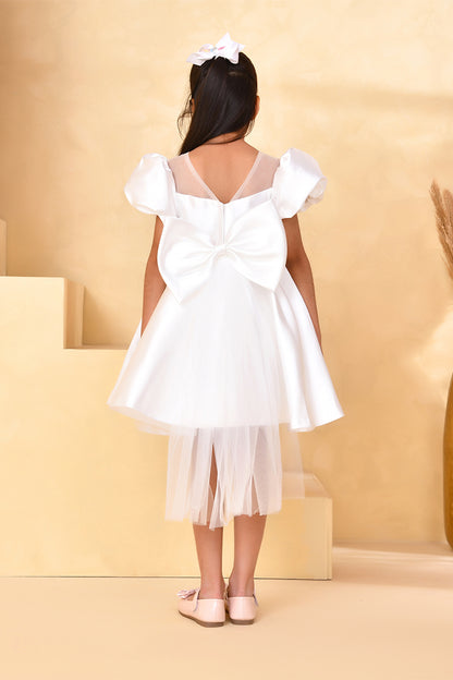 White dress with a large bow on a yellow background
